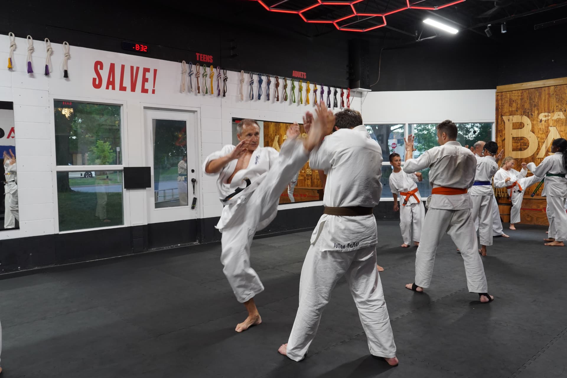 Black belt instructor throwing a high kick during Kyokushin karate class at Z GRVTY