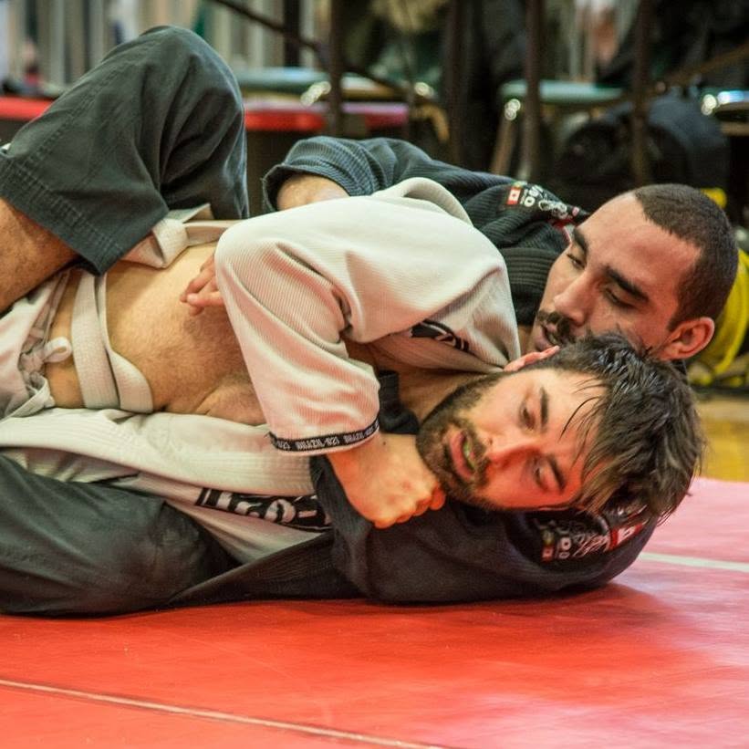 Two athletes battling for position on the ground in BJJ